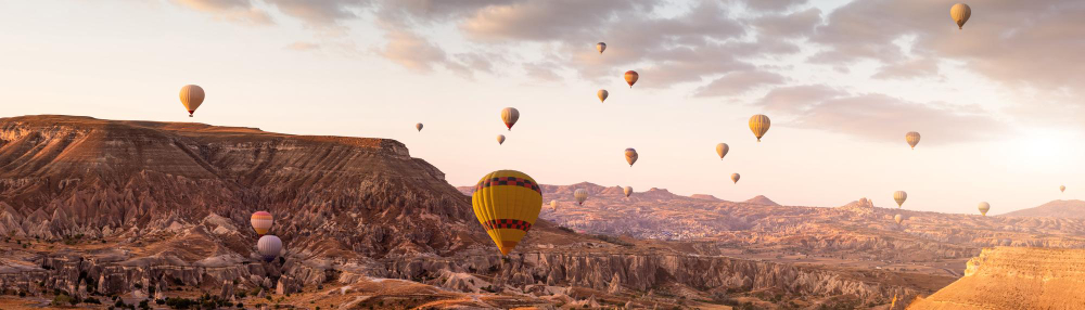 Float over the otherworldly landscapes of Cappadocia, where fairy chimneys and ancient cave dwellings create a surreal backdrop